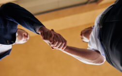 Business people shaking hands to express unity after successful negotiation, view from below