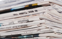 close up of different print daily newspapers in stack